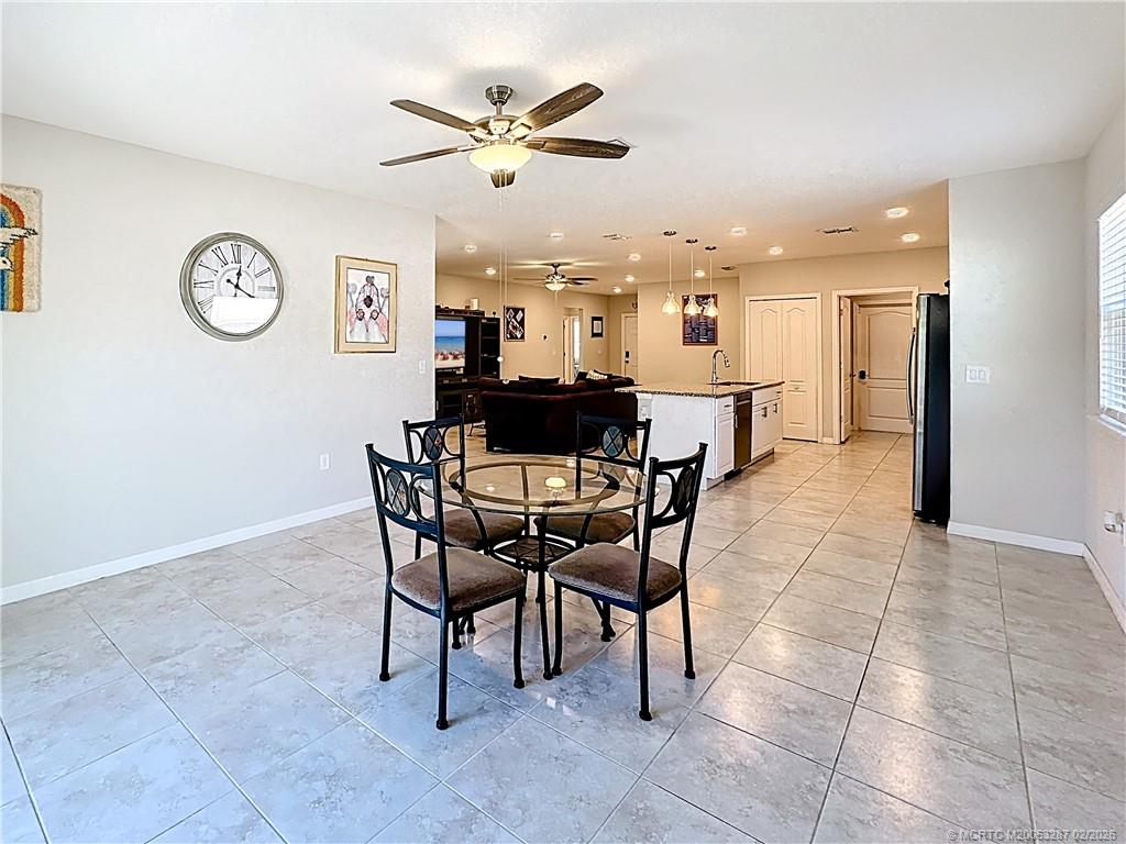 4341 Southwest Appleseed Road Port St. Lucie, FL 34953 - Photo 24 of 25 a view of a dining room and livingroom with furniture a rug a fireplace and a chandelier