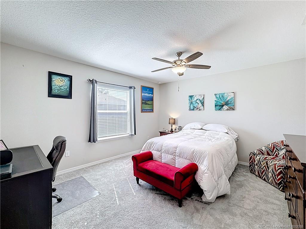 4341 Southwest Appleseed Road Port St. Lucie, FL 34953 - Photo 6 of 25 a bedroom with a bed and a chandelier