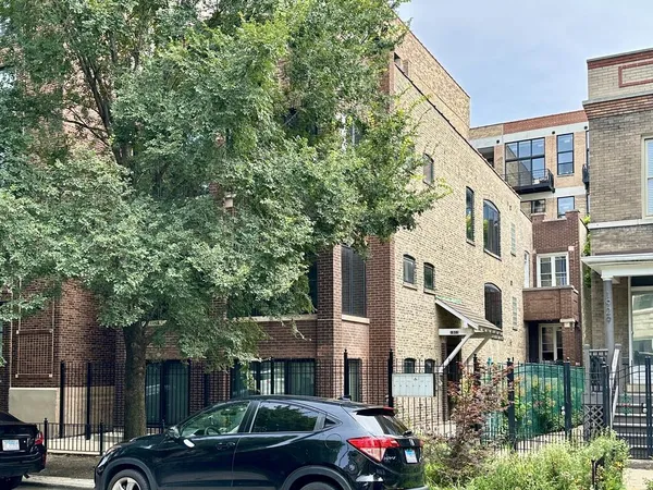 a front view of a building with trees
