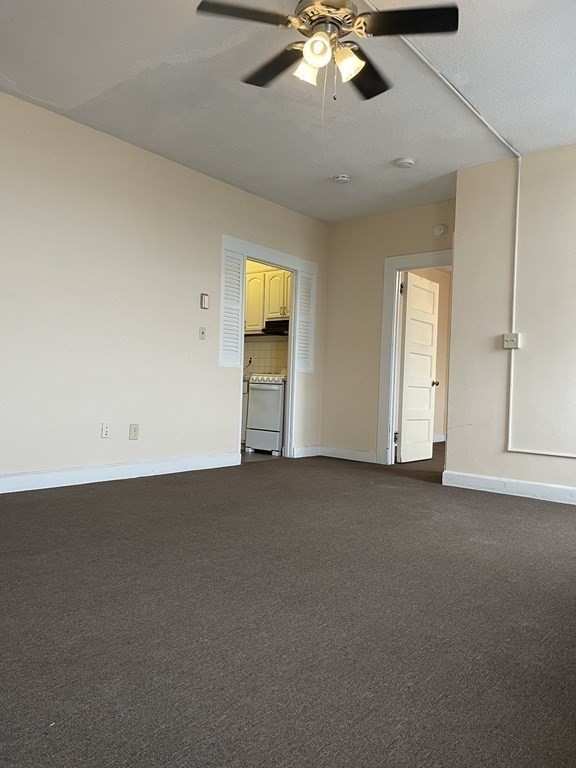 140 Chestnut Street, Unit 510 Springfield, MA 01103 - Photo 11 of 12 an empty room with a chandelier fan and windows