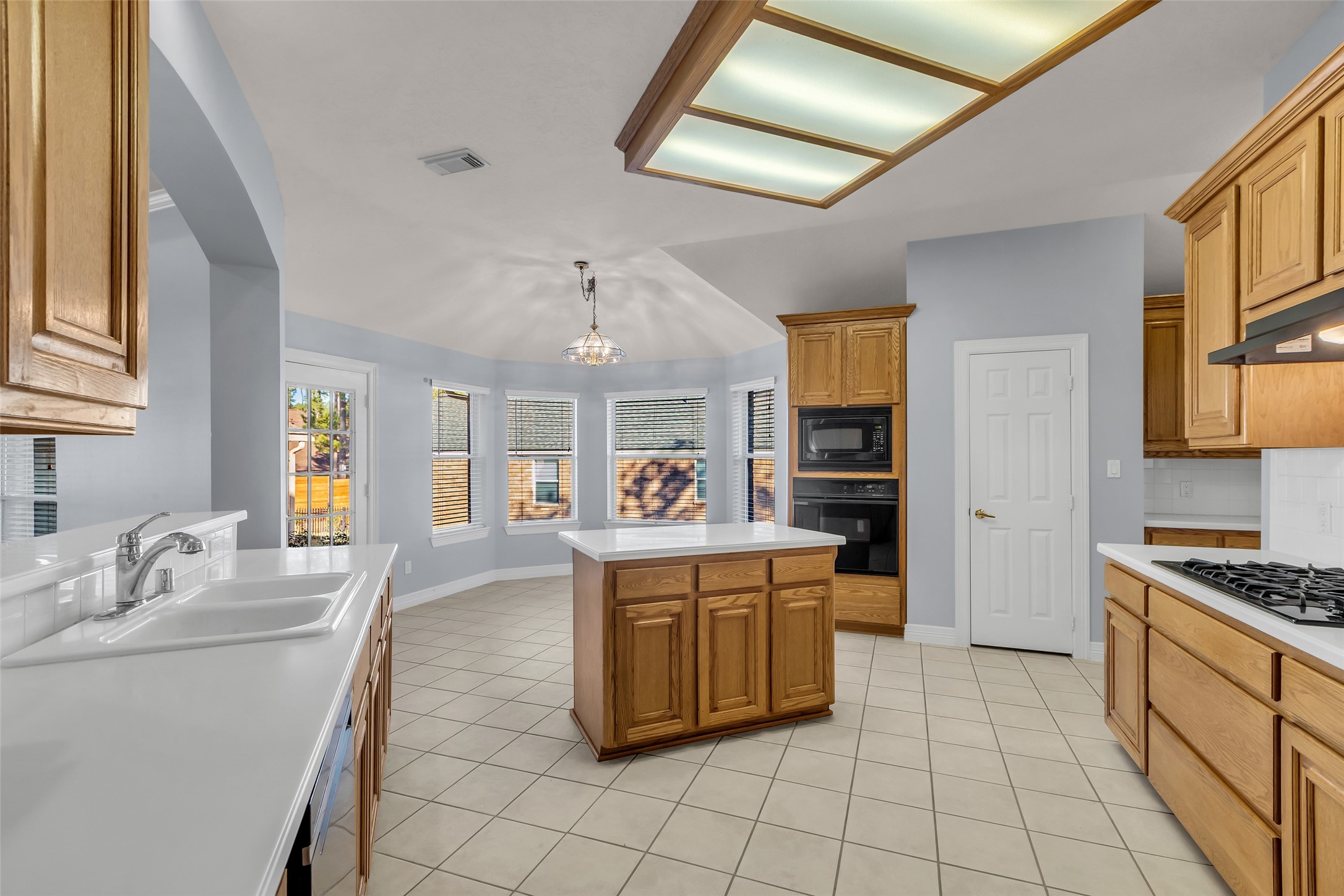35 West Pines Drive Montgomery, TX 77356 - Photo 6 of 30 a large kitchen with kitchen island a stove a sink a dining table and chairs with wooden floor