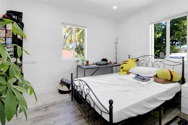 a bedroom with a bed and a potted plant