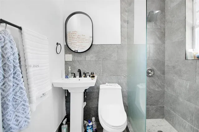 a bathroom with a sink a toilet and a mirror