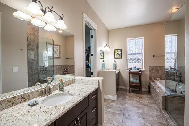 a bathroom with a granite countertop sink a toilet a mirror and shower