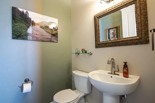 a bathroom with a toilet sink and mirror
