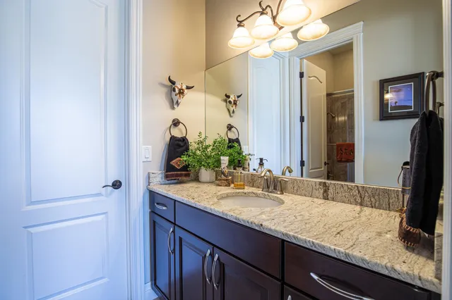 a bathroom with a granite countertop sink and a mirror