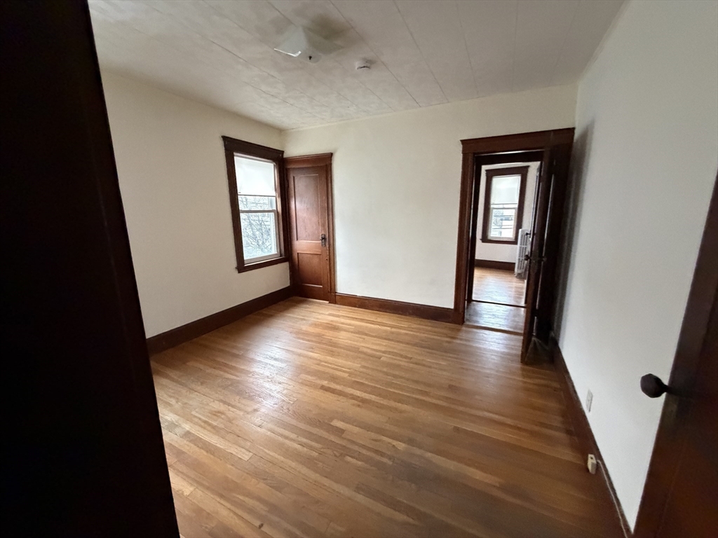 44 Varnum Street, Unit 2 Arlington, MA 02474 - Photo 12 of 19 wooden floor in an empty room with a window