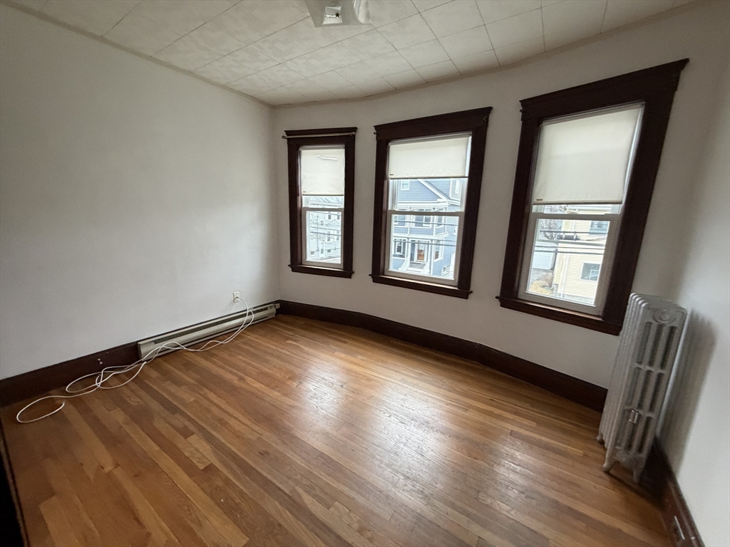 44 Varnum Street, Unit 2 Arlington, MA 02474 - Photo 14 of 19 an empty room with wooden floor and windows