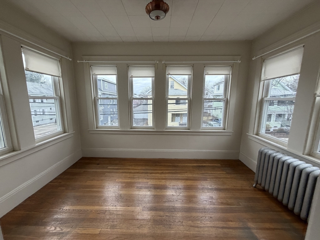 44 Varnum Street, Unit 2 Arlington, MA 02474 - Photo 15 of 19 a view of an empty room with wooden floor and a window
