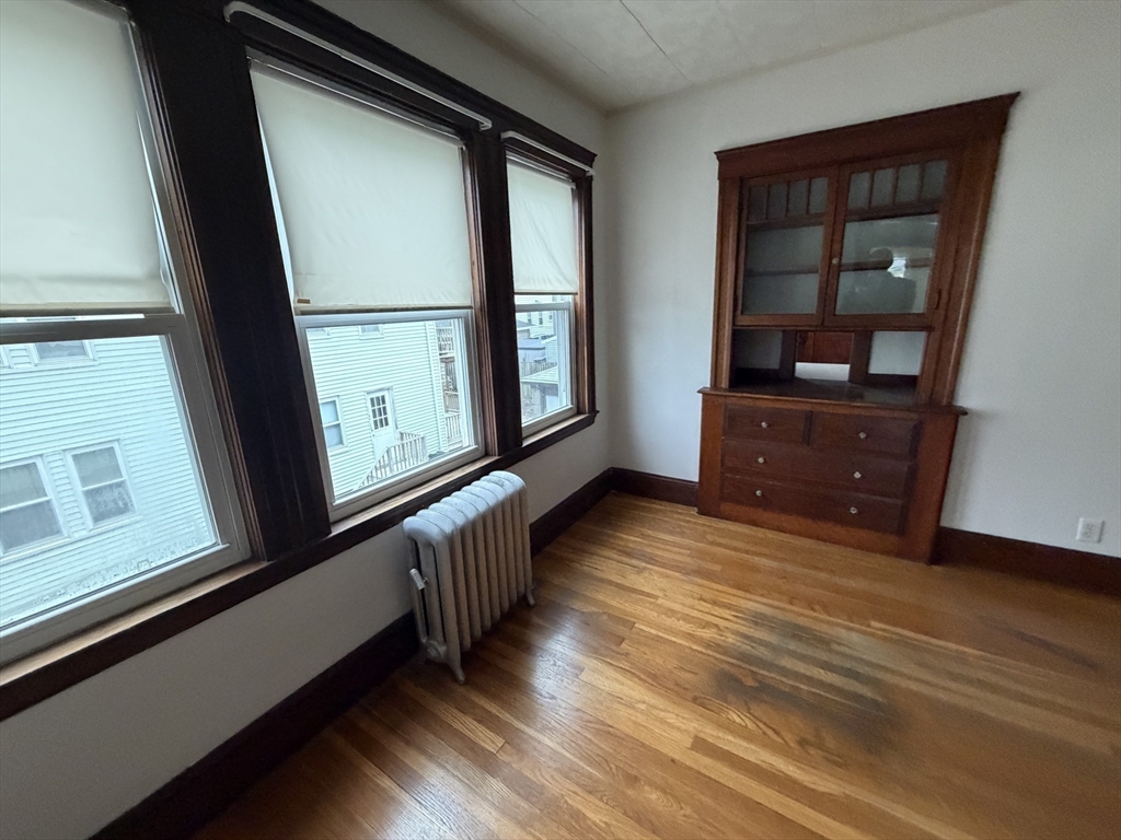 44 Varnum Street, Unit 2 Arlington, MA 02474 - Photo 6 of 19 a view of a hallway with wooden floor and windows