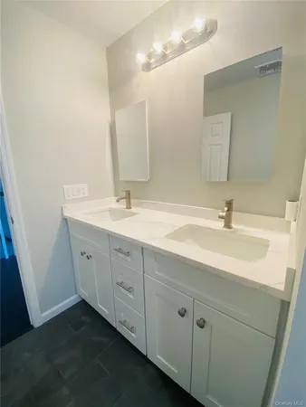 a bathroom with a double vanity sink and mirror