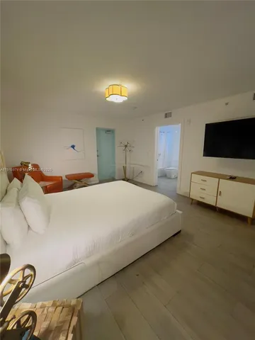 a bedroom with a bed and a flat screen tv