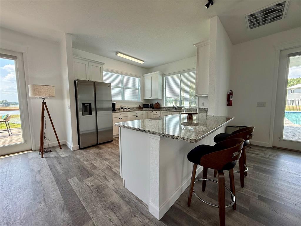 2783 Sycamore Street Winter Haven, FL 33881 - Photo 28 of 32 a kitchen with a refrigerator a stove a sink and a dining table with wooden floor