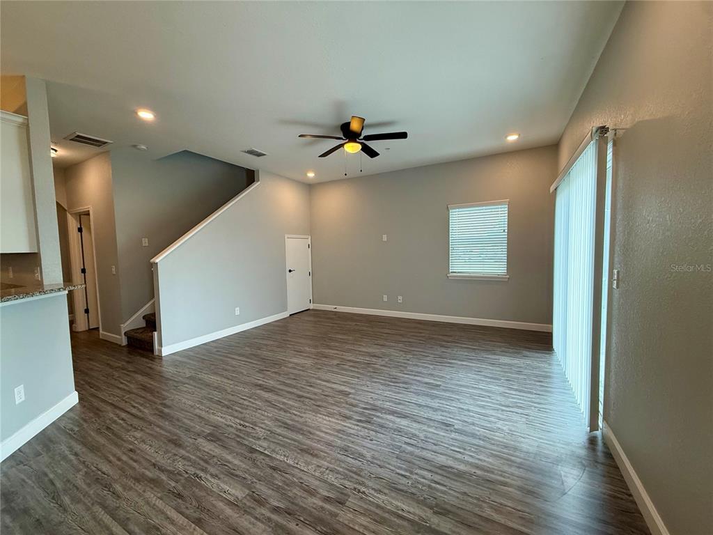 2783 Sycamore Street Winter Haven, FL 33881 - Photo 3 of 32 an empty room with wooden floor chandelier fan and windows