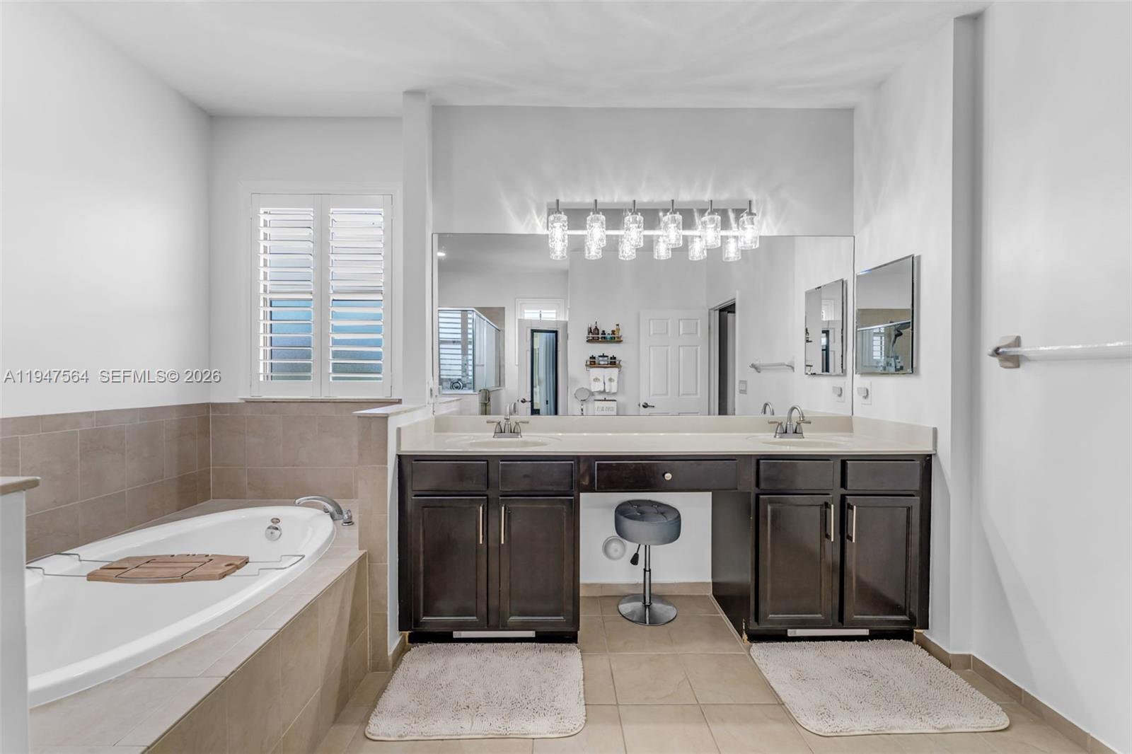17475 Southwest 153rd Avenue Miami, FL 33187 - Photo 25 of 46 a spacious bathroom with a double vanity sink a mirror and a bathtub
