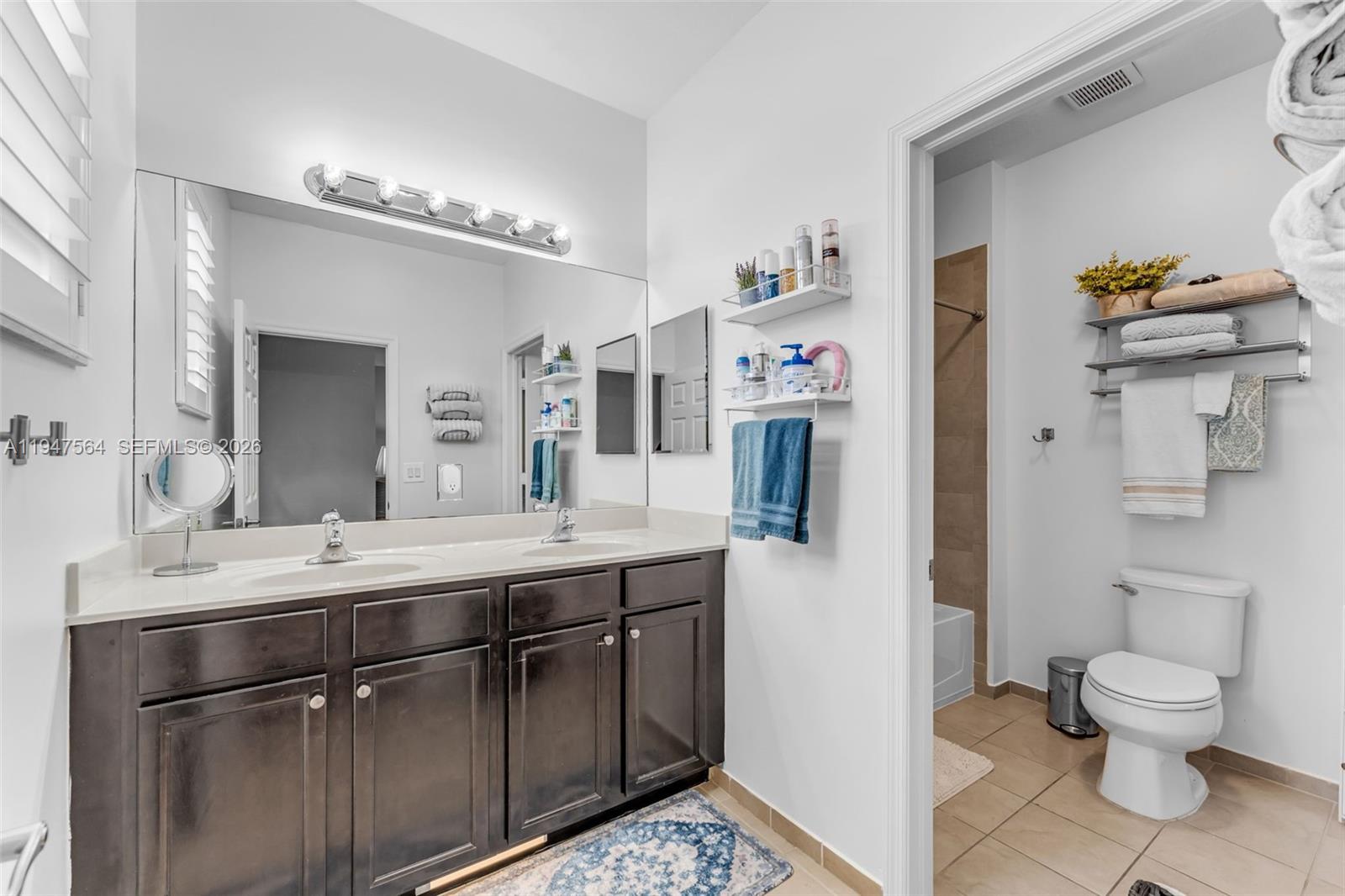 17475 Southwest 153rd Avenue Miami, FL 33187 - Photo 28 of 46 a bathroom with a sink a toilet and a mirror