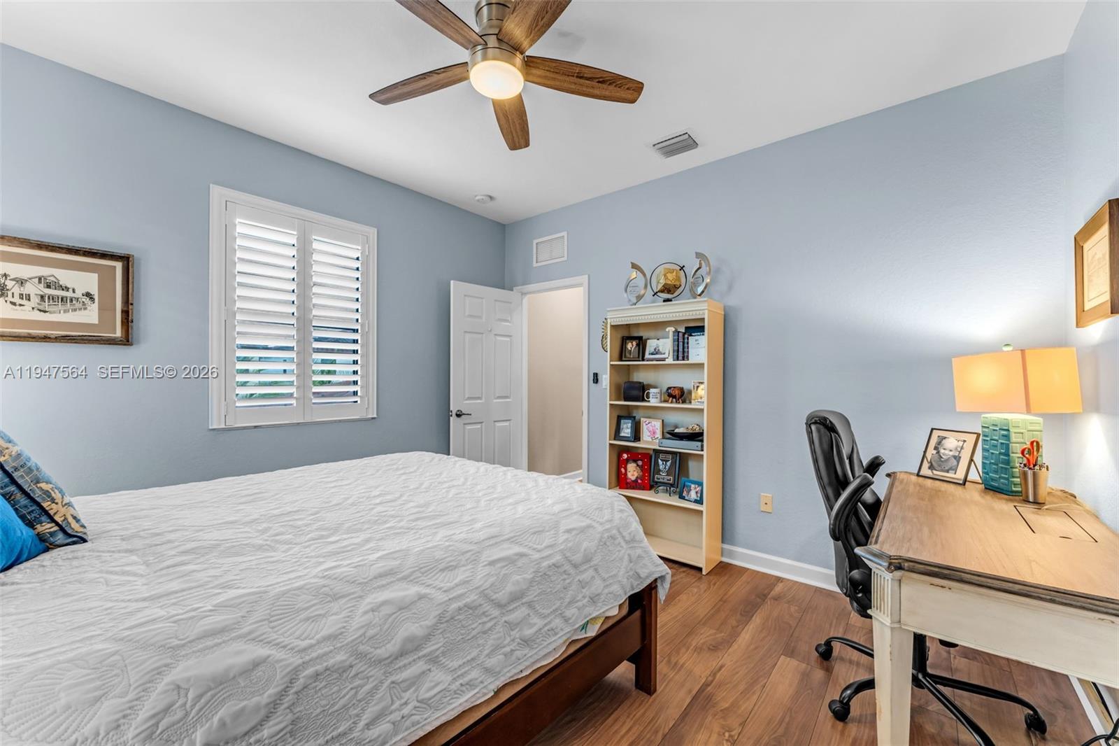 17475 Southwest 153rd Avenue Miami, FL 33187 - Photo 32 of 46 a bedroom with a bed a computer on a desk and a book shelf