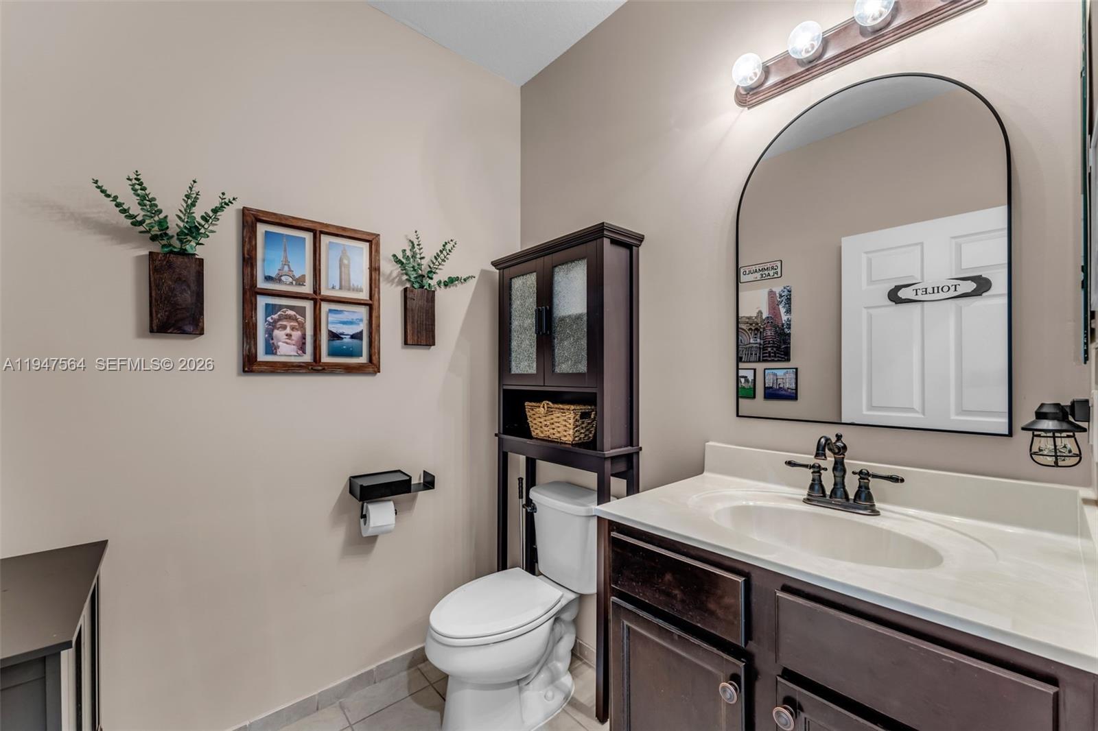 17475 Southwest 153rd Avenue Miami, FL 33187 - Photo 9 of 46 a bathroom with a granite countertop toilet a sink and a mirror