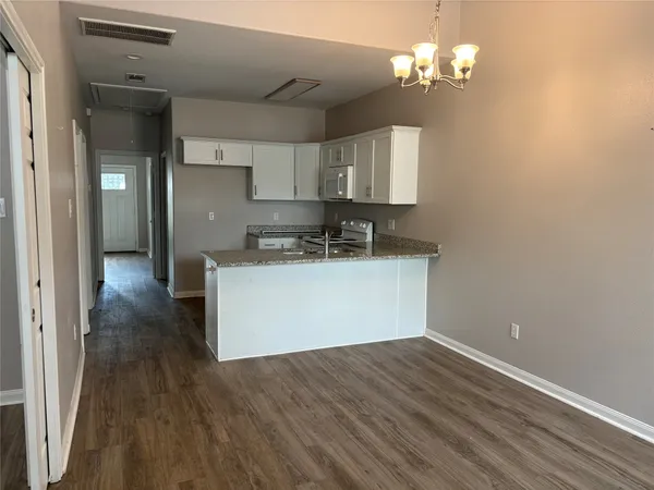 a view of a kitchen with a sink wooden floor and cabinets