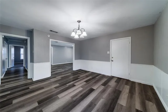 a view of an empty room and wooden floor
