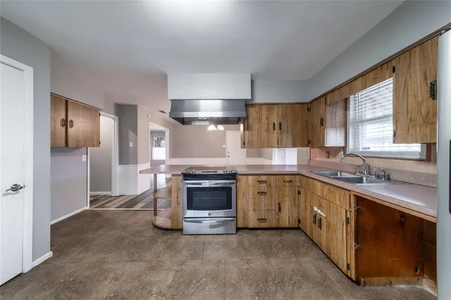 a kitchen with granite countertop stainless steel appliances a sink stove and refrigerator