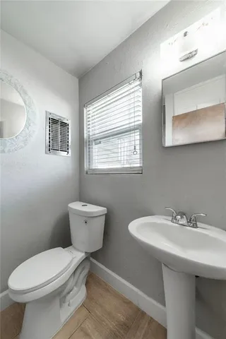 a bathroom with a toilet a sink and mirror