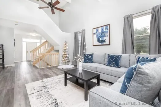 a living room with furniture and a wooden floor
