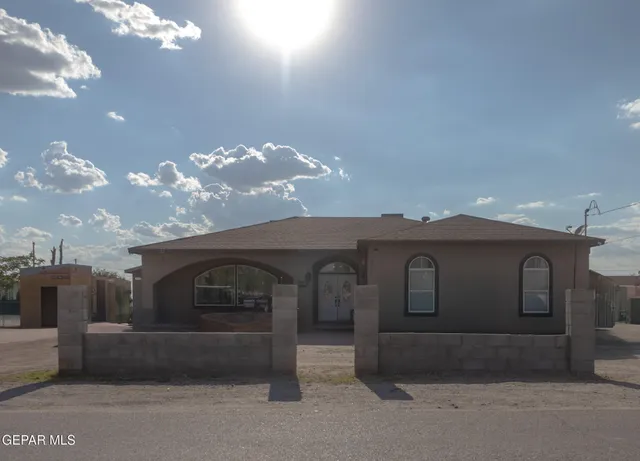 a kitchen with stainless steel appliances granite countertop a refrigerator a stove a sink a dining table and chairs with wooden floor