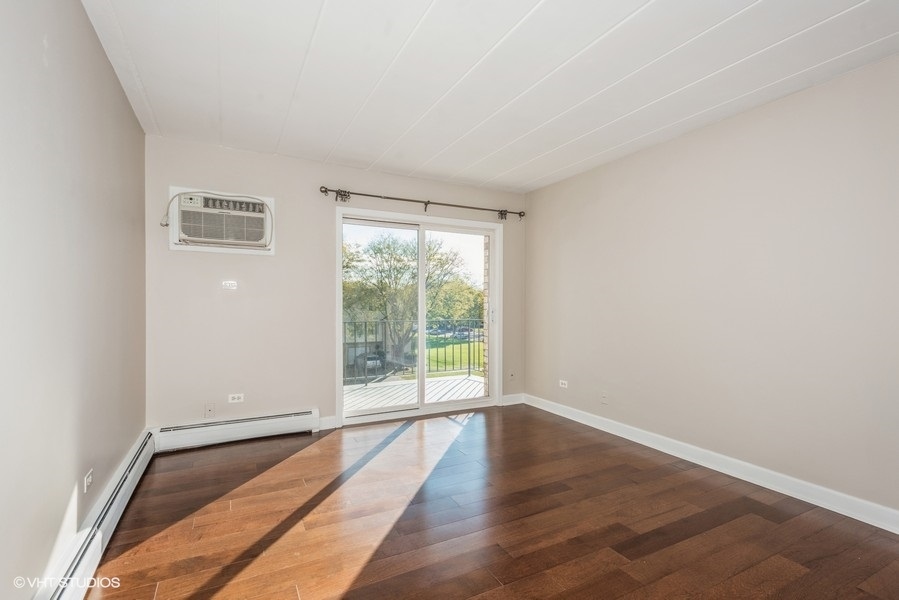 1000 South Lorraine Road, Unit 307 Wheaton, IL 60189 - Photo 2 of 10 a view of an empty room with wooden floor and a window