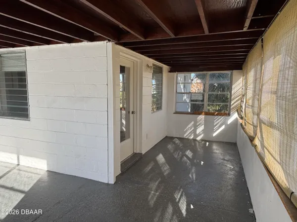 a view of an empty room with a fireplace and a window