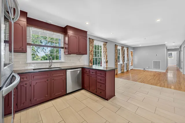 a view of a hallway with wooden floor and a bathroom