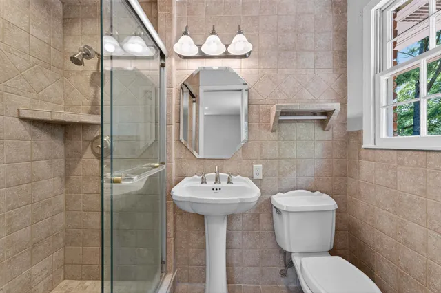 a bathroom with a sink a toilet and a mirror