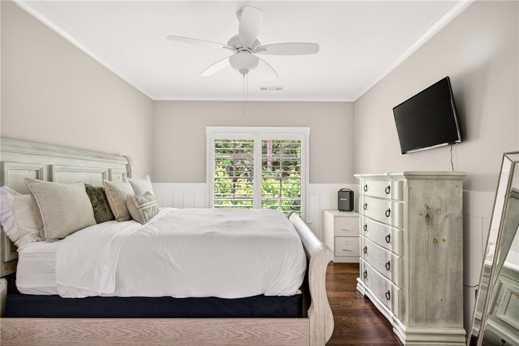 13460 New Providence Road Milton, GA 30004 - Photo 29 of 60 a bedroom with a bed a flat screen tv and a chandelier