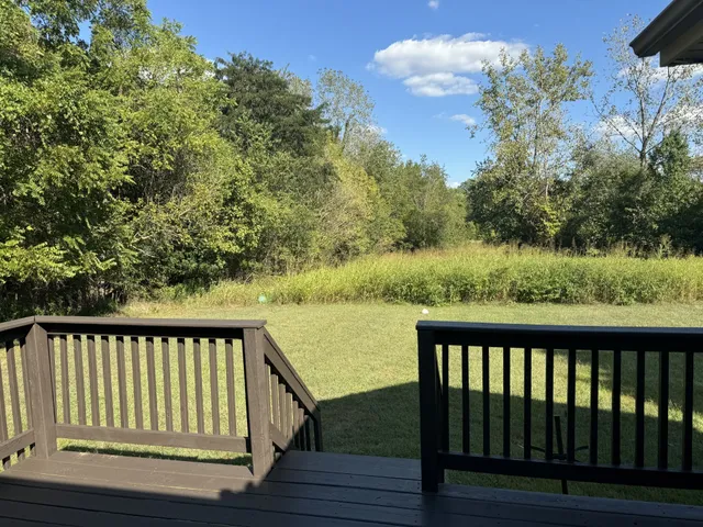 a balcony with wooden floor and lake view