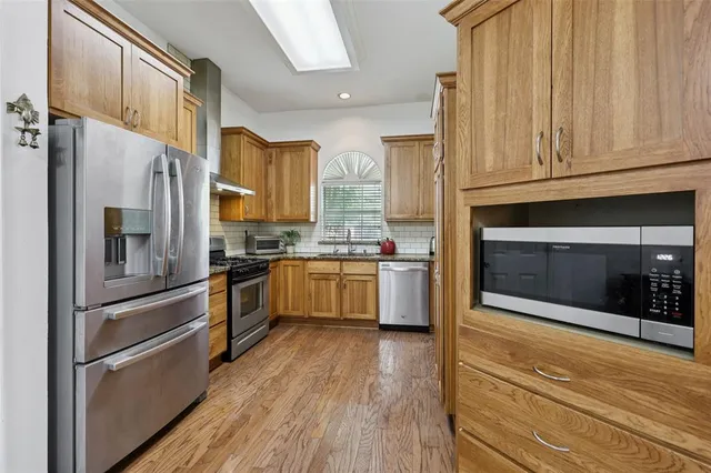 a kitchen with stainless steel appliances a refrigerator sink and cabinets