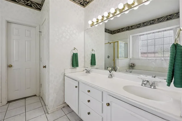 a bathroom with a double vanity sink mirror and chandelier