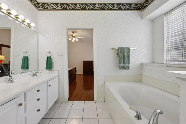 a spacious bathroom with a tub sink and mirror