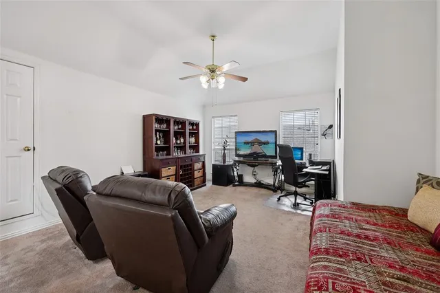 a living room with furniture a ceiling fan and a rug
