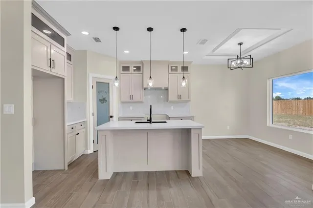 a kitchen with stainless steel appliances a sink cabinets and wooden floor