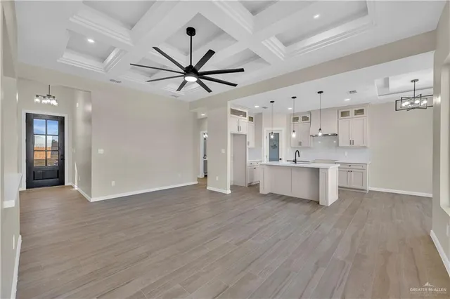 a view of a kitchen with a sink a ceiling fan and wooden floor