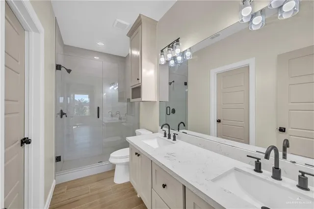a bathroom with a sink double vanity granite tub and shower