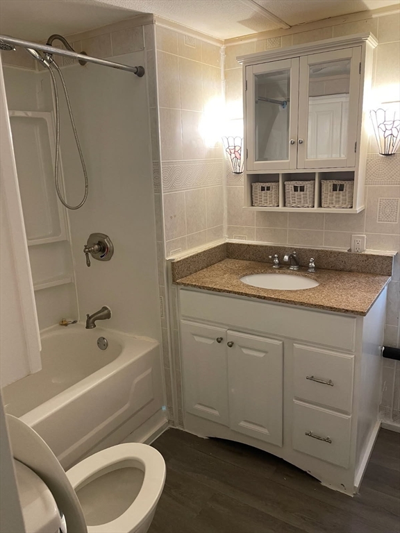 252 Newbury Street, Unit 71 Peabody, MA 01960 - Photo 18 of 22 a bathroom with a granite countertop sink toilet and shower