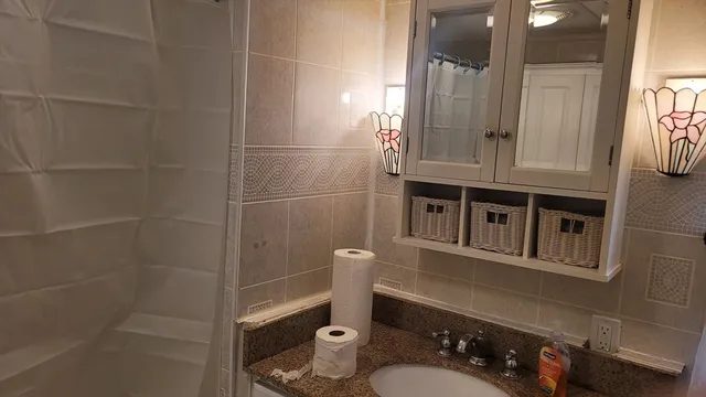 a bathroom with a sink a toilet and shower