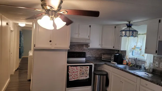 a kitchen with stainless steel appliances granite countertop a sink a stove and a refrigerator