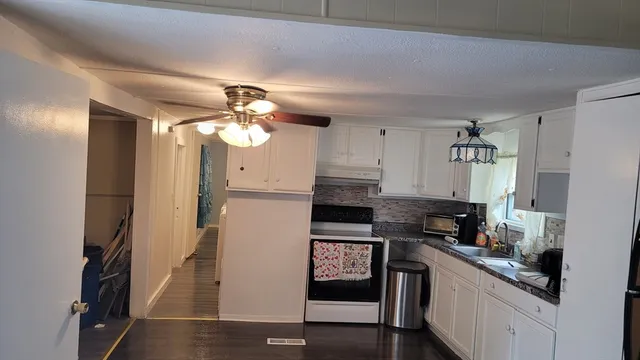 a kitchen with stainless steel appliances granite countertop a refrigerator a stove and a sink