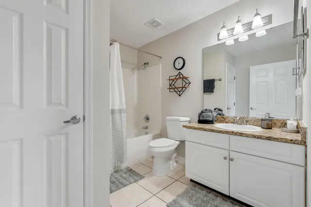 a bathroom with a granite countertop sink a toilet and a mirror
