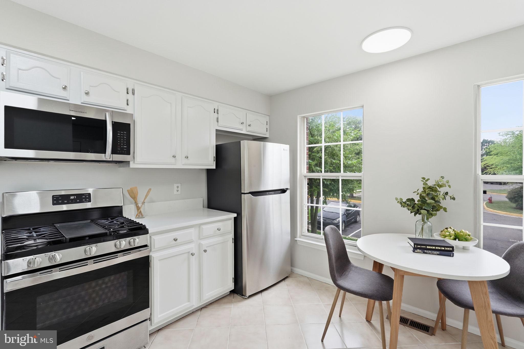 6010 Bingley Road Alexandria, VA 22315 - Photo 15 of 50 a kitchen with stainless steel appliances a white refrigerator stove a microwave and dining table