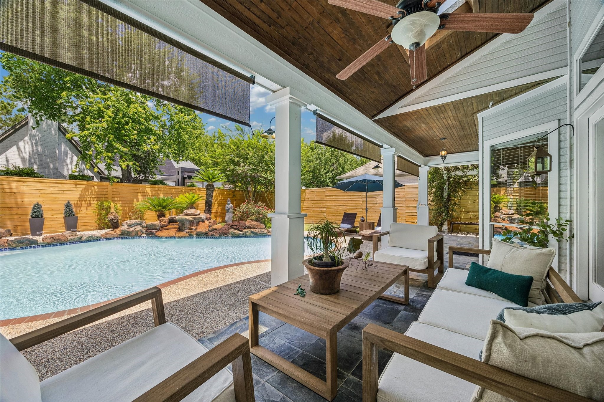146 Golden Shadow Circle Spring, TX 77381 - Photo 38 of 41 A view of the covered back patio showcases warm wood-lined ceilings, outdoor shades, and ample space for seating and gathering. This inviting outdoor living area is perfect for relaxing, dining, or entertaining!