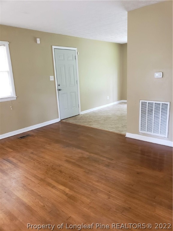 618 Pleasant Loop Fayetteville, NC 28311 - Photo 7 of 25 an empty room with wooden floor and windows