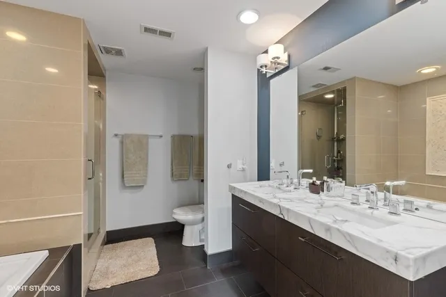 a bathroom with a double vanity sink a toilet and a mirror